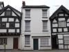 early 19th century front to an earlier core; 20th century shop window to right