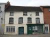 18th century front to a 17th century core; 19th century shop front to right