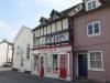 built in the 17th century; timber-frame and roughcast; early 20th century shop front and door